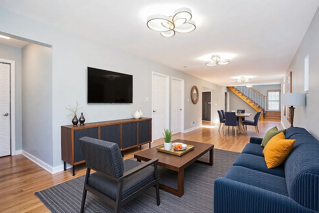 living room with stairway, wood finished floors, and baseboards