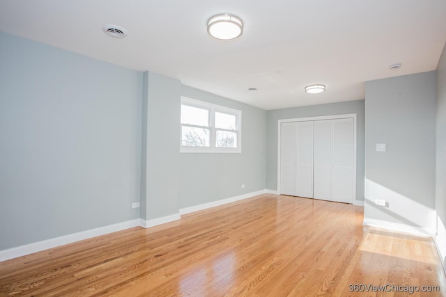 unfurnished bedroom with light hardwood / wood-style floors and a closet