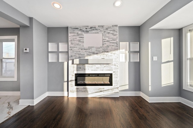 unfurnished living room featuring a fireplace and dark hardwood / wood-style floors