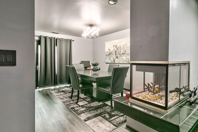 dining room with hardwood / wood-style floors and an inviting chandelier