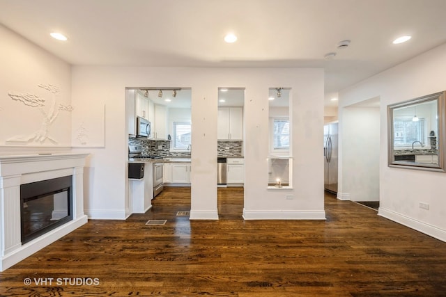 unfurnished living room featuring dark hardwood / wood-style flooring and sink