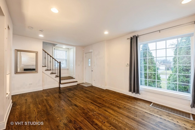 entrance foyer with dark hardwood / wood-style flooring and a healthy amount of sunlight