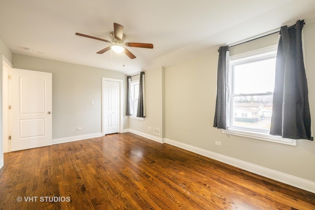 empty room with a healthy amount of sunlight, ceiling fan, and wood-type flooring