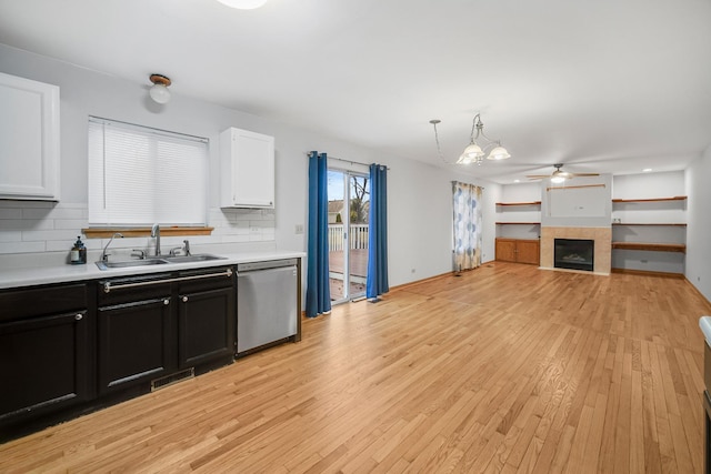 kitchen featuring decorative backsplash, stainless steel dishwasher, sink, pendant lighting, and white cabinets