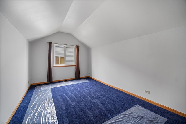 additional living space with carpet flooring and vaulted ceiling