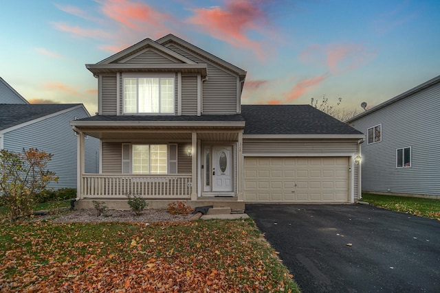 view of property with a porch and a garage