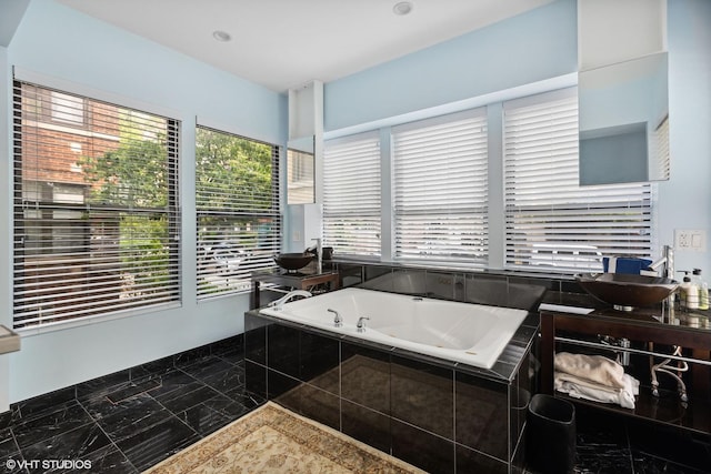 bathroom with a relaxing tiled tub and a wealth of natural light