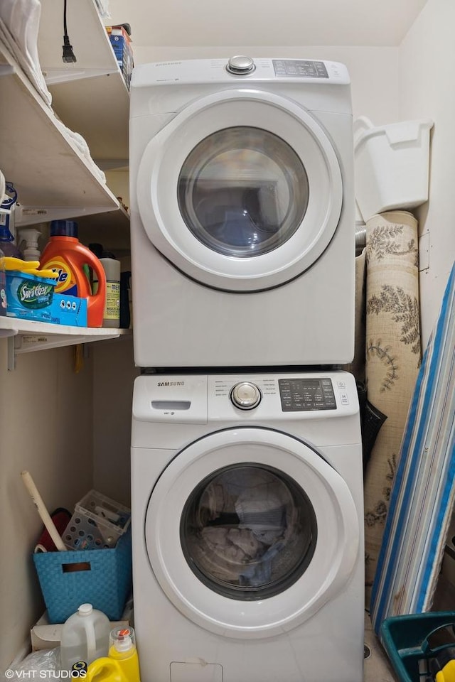 clothes washing area featuring stacked washer and clothes dryer