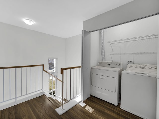 clothes washing area with dark wood-type flooring and washing machine and clothes dryer