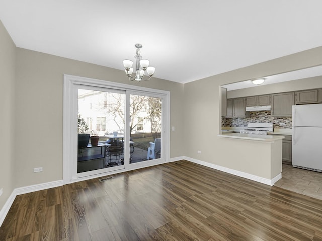 unfurnished dining area featuring dark wood-type flooring and a notable chandelier