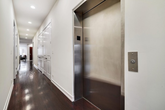 corridor featuring dark hardwood / wood-style flooring and elevator