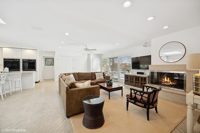 living room with ceiling fan and light hardwood / wood-style floors