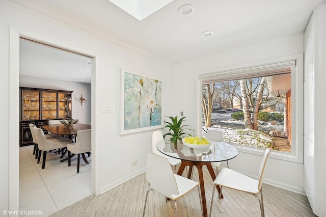 dining space featuring crown molding and light hardwood / wood-style flooring