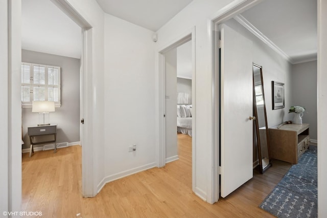 hall with wood-type flooring and ornamental molding