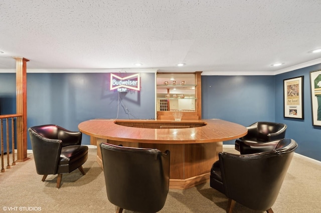 bar featuring ornamental molding, decorative columns, a textured ceiling, and carpet