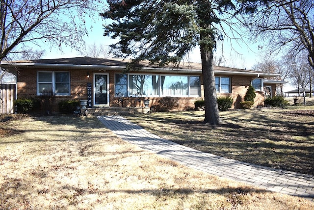 ranch-style house featuring brick siding and a front lawn