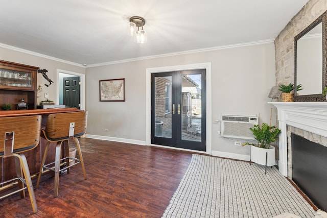 interior space featuring a wall mounted air conditioner, baseboards, wood finished floors, and crown molding