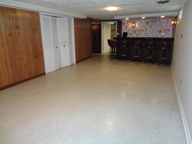 basement with bar and wooden walls