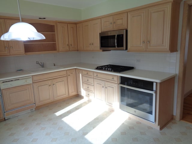 kitchen with pendant lighting, light brown cabinets, sink, tasteful backsplash, and stainless steel appliances