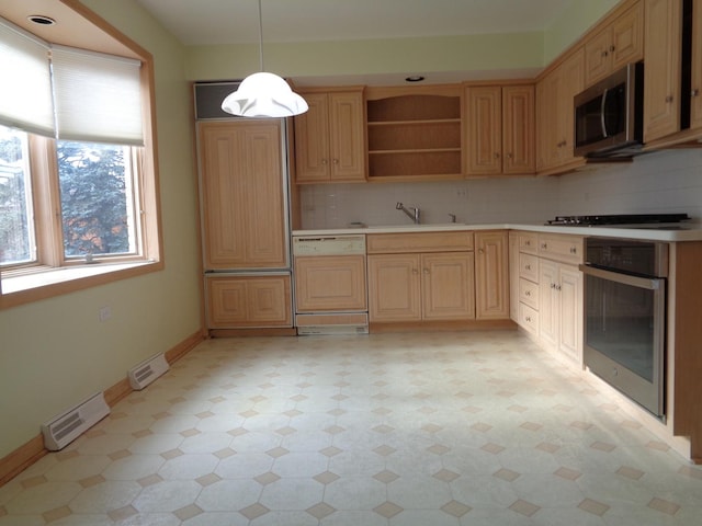 kitchen with tasteful backsplash, stainless steel appliances, hanging light fixtures, and sink