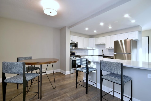 kitchen with sink, white cabinetry, decorative backsplash, and stainless steel appliances