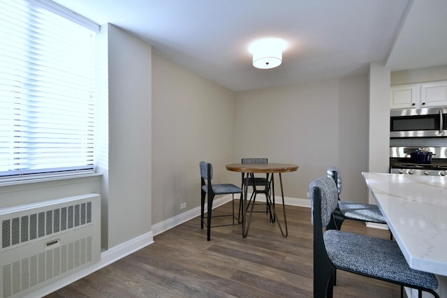 dining room with radiator and dark hardwood / wood-style flooring