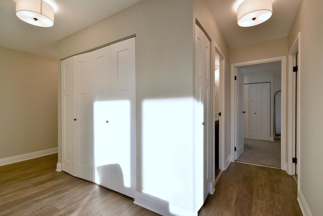 corridor with hardwood / wood-style flooring