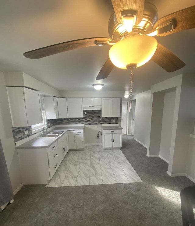 kitchen with white cabinetry, sink, ceiling fan, tasteful backsplash, and light carpet