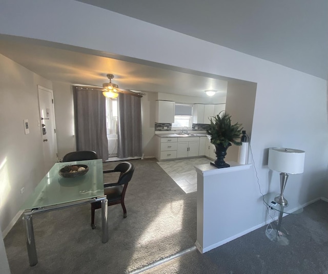 carpeted dining area with ceiling fan and sink