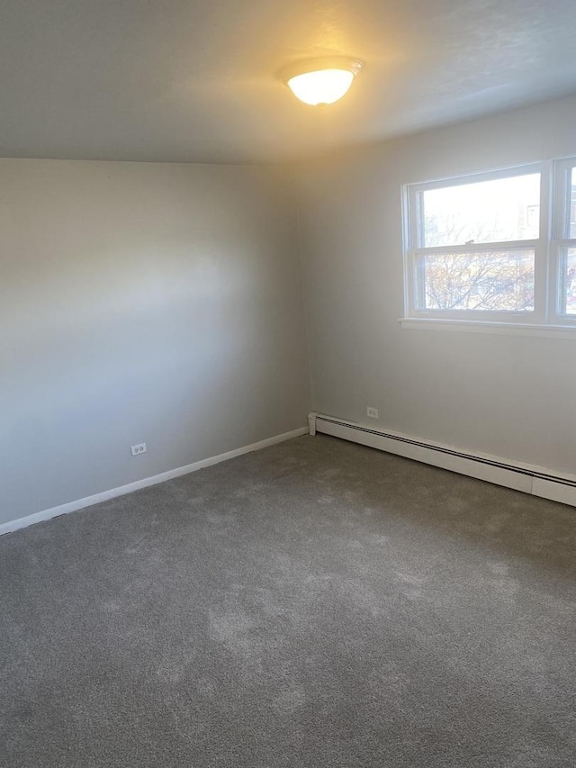 spare room featuring carpet flooring and a baseboard radiator