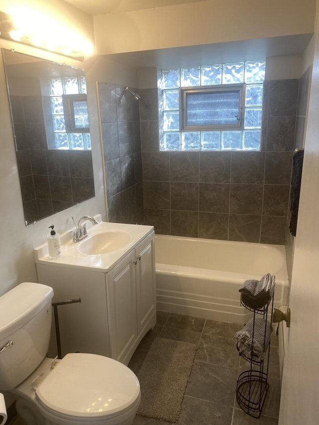 full bathroom featuring vanity, tiled shower / bath combo, and toilet