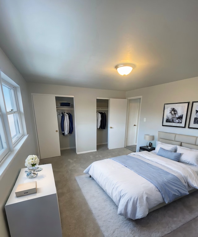 carpeted bedroom featuring multiple closets