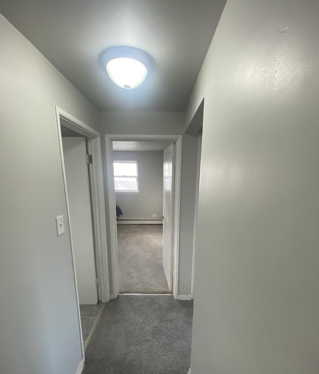 hall featuring dark carpet and a baseboard heating unit