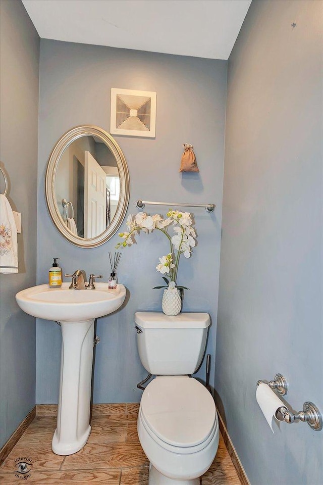 bathroom with hardwood / wood-style flooring and toilet