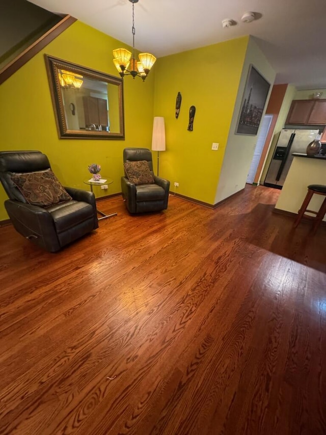 living area with wood-type flooring and an inviting chandelier