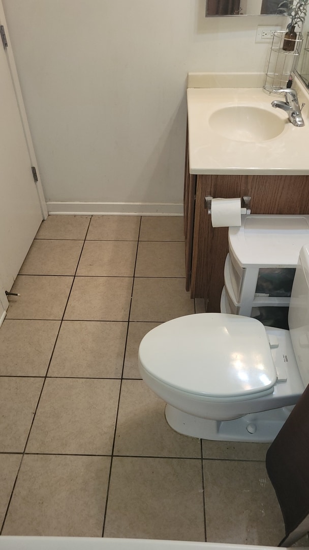 bathroom with tile patterned flooring, vanity, and toilet