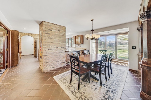 dining room featuring dark tile patterned floors, a notable chandelier, and sink