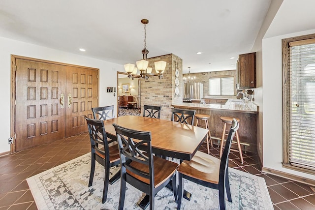 tiled dining room featuring sink and a chandelier