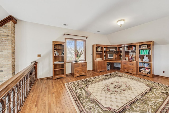 home office featuring wood-type flooring and vaulted ceiling