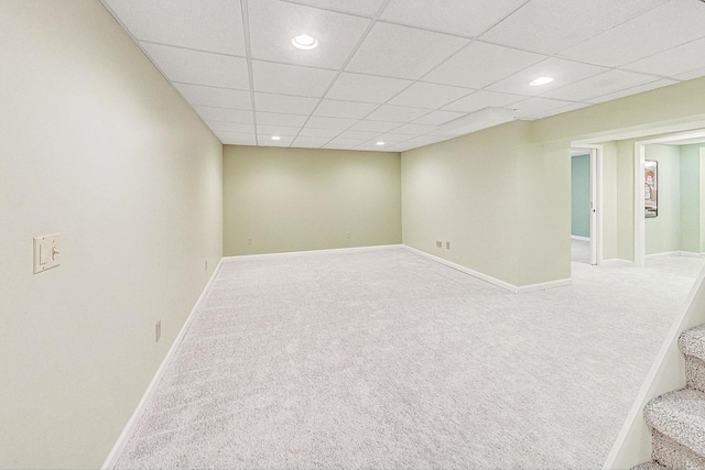 empty room featuring carpet floors and a paneled ceiling