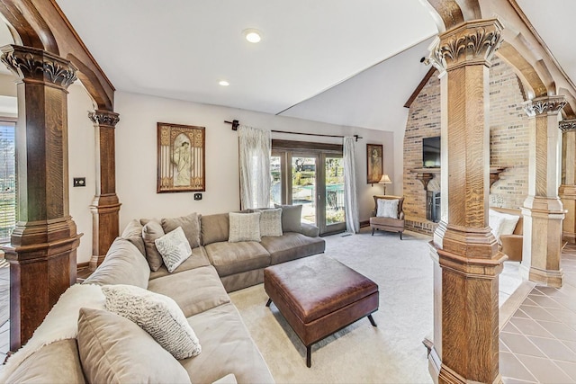 living room featuring light tile patterned floors, ornate columns, and lofted ceiling