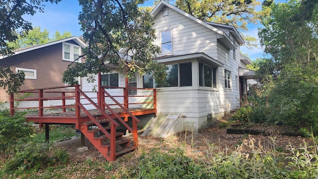 rear view of house featuring a wooden deck