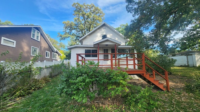 rear view of house featuring a wooden deck