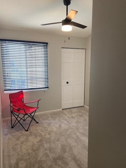 unfurnished room featuring light colored carpet and ceiling fan