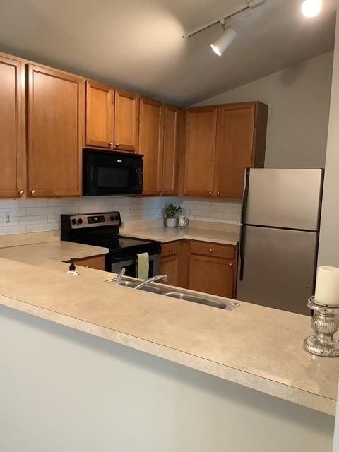 kitchen with decorative backsplash, stainless steel appliances, vaulted ceiling, and sink