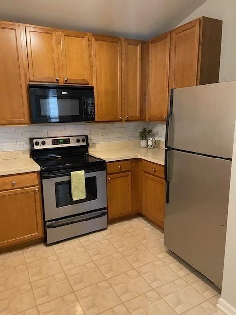 kitchen with stainless steel appliances and tasteful backsplash