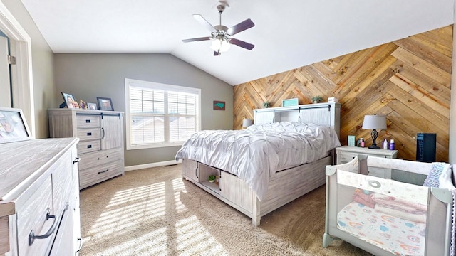 bedroom with lofted ceiling, light colored carpet, ceiling fan, and wooden walls