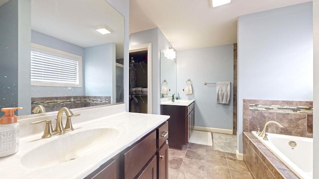 bathroom with vanity and tiled tub