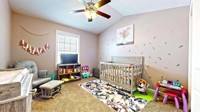 bedroom featuring ceiling fan, a crib, carpet floors, and lofted ceiling