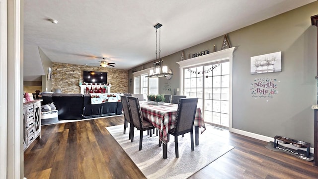 dining space with ceiling fan and dark wood-type flooring